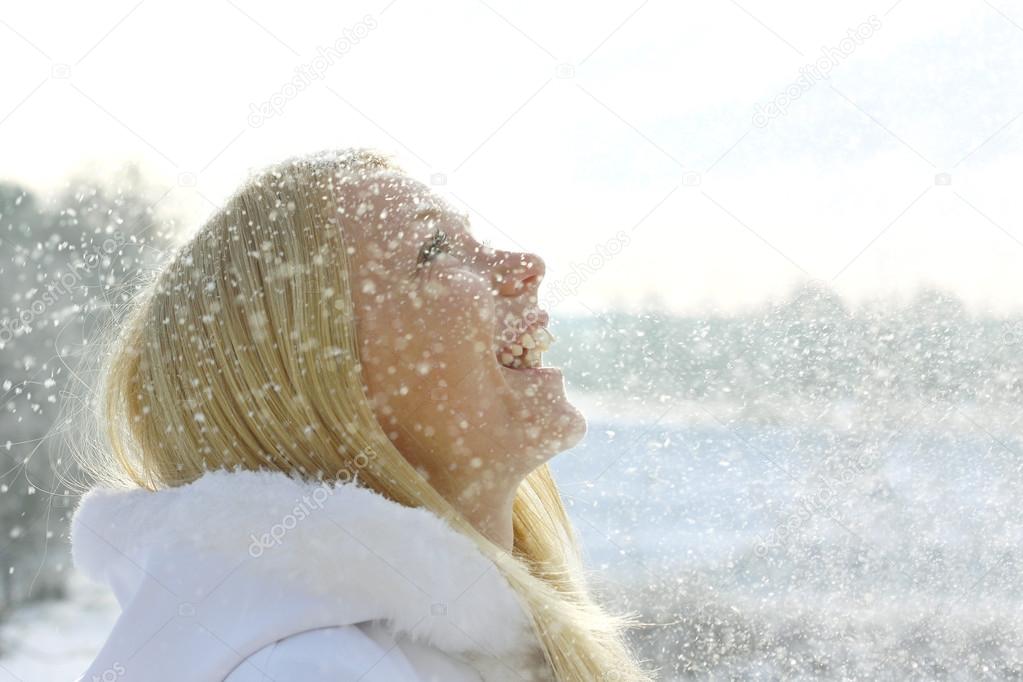 Happy Woman Enjoying Snow Falling Outside in Winter
