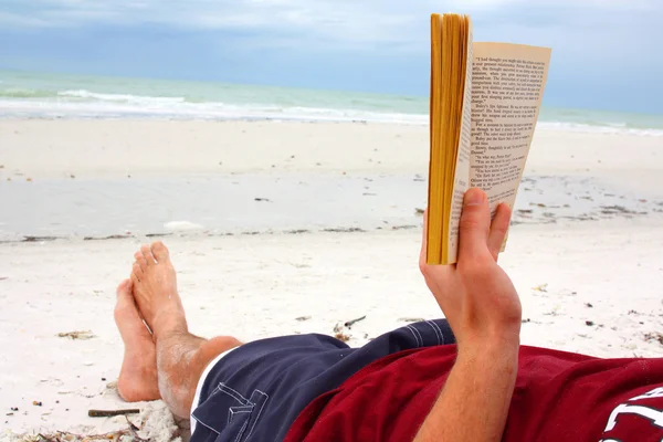 Muž čtení knihy na ocean beach — Stock fotografie