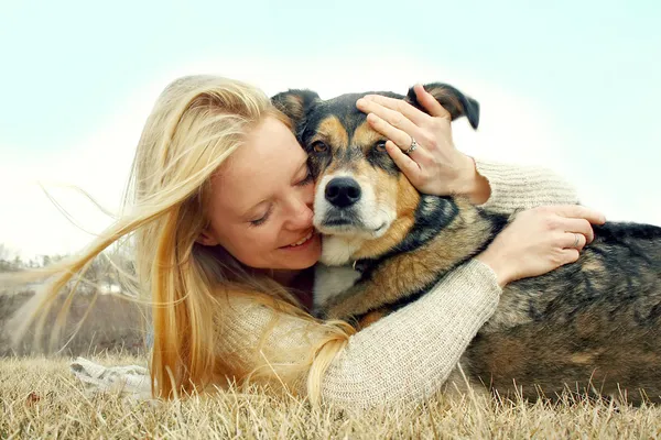 Mulher amorosamente abraçando cão pastor alemão — Fotografia de Stock