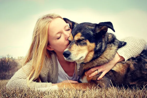 Vrouw teder knuffelen en zoenen huisdier hond — Stockfoto