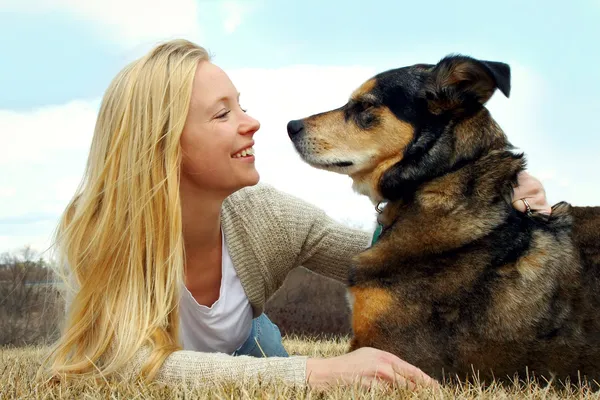 Vrouw haar Duitse herder buiten aaien — Stockfoto