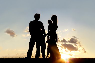 mutlu aile ve köpek dışında gün batımında silüeti