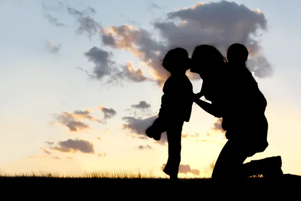 Mutter und zwei kleine Kinder umarmen und küssen sich — Stockfoto