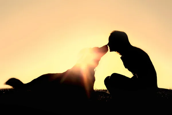 Gelukkige vrouw en hond buiten silhouet — Stockfoto