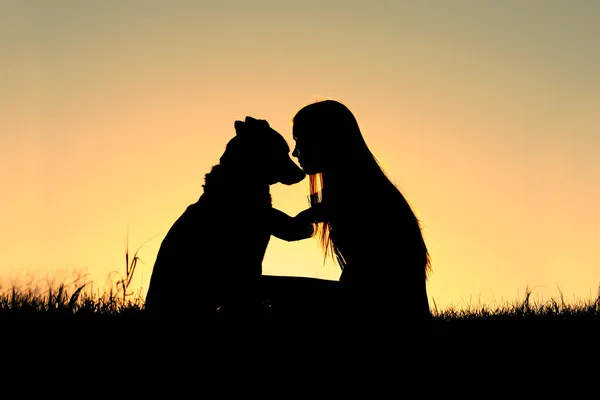 Kobieta tulenie pies sylwetka — Zdjęcie stockowe