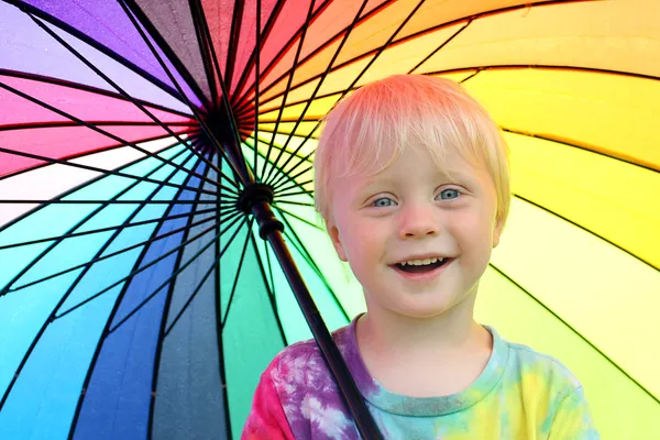 Carino piccolo bambino sotto arcobaleno colorato ombrello — Foto Stock