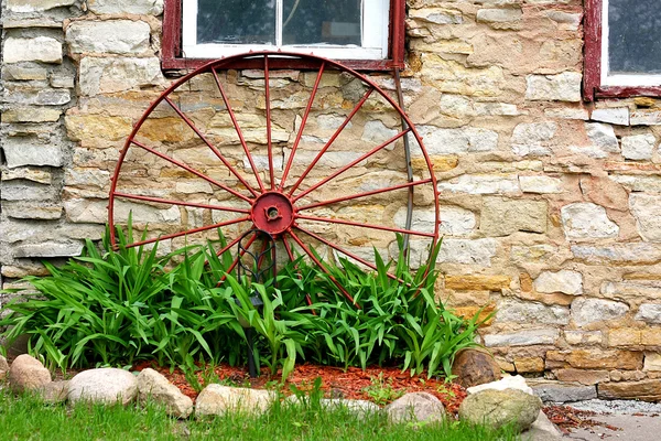 Old Wagon Wheel in Front of Stone Barn — Stock Photo, Image