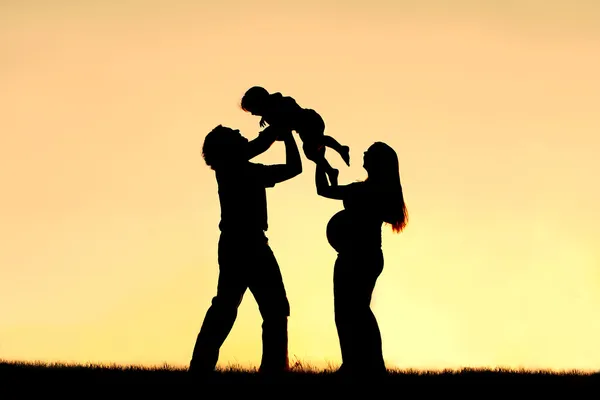Silhouette della famiglia felice che celebra la gravidanza — Foto Stock
