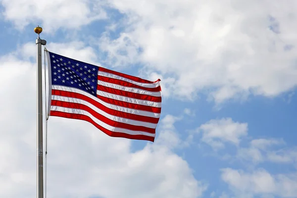 Bandera americana frente al cielo azul nublado — Foto de Stock