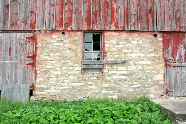 Staré opuštěné stodoly s rozbitým oknem a dvoje dřevěné dveře — Stock fotografie