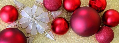 Kırmızı Noel ampul süslemeleri ve bir yıldız şeklinde ağaç topper sınır kopya alanı ile bir arka plan altın glitter kumaş üst.