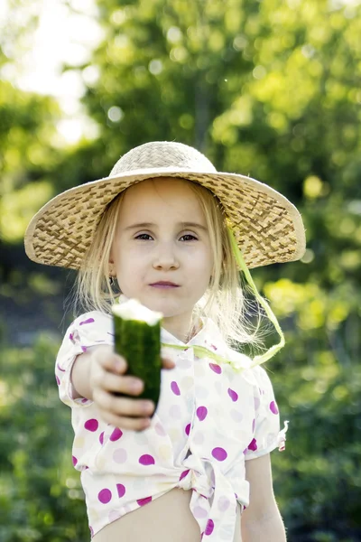 Chica joven con pepino en el jardín — Foto de Stock