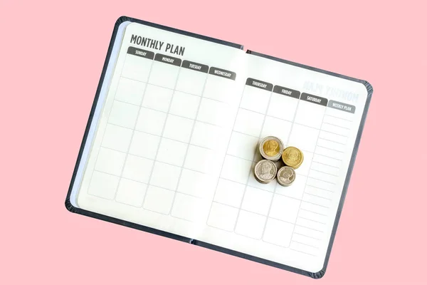 顶部视图钱币堆放在空白的月度计划笔记本上 与白色背景隔离 消费计划或储蓄的概念 收割路径 — 图库照片