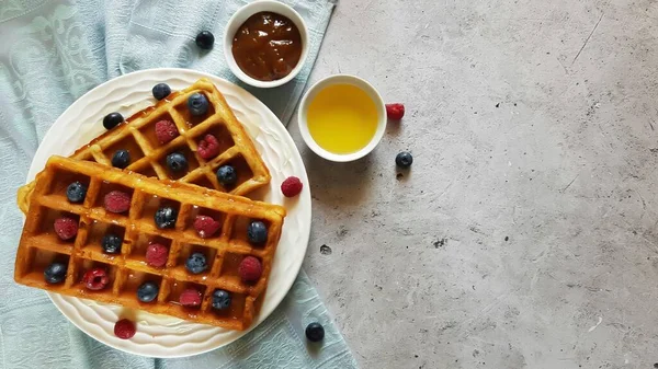 Traditionelle Waffeln mit frischen Himbeeren und Blaubeeren auf Betongrund.. — Stockfoto