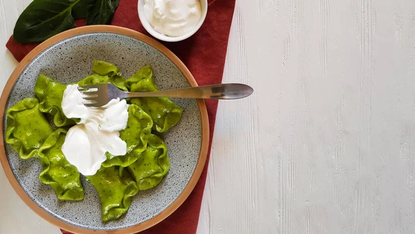 Groene knoedels met kwark en spinazie op keramische plaat met rood textiel op witte achtergrond met kopieerruimte — Stockfoto