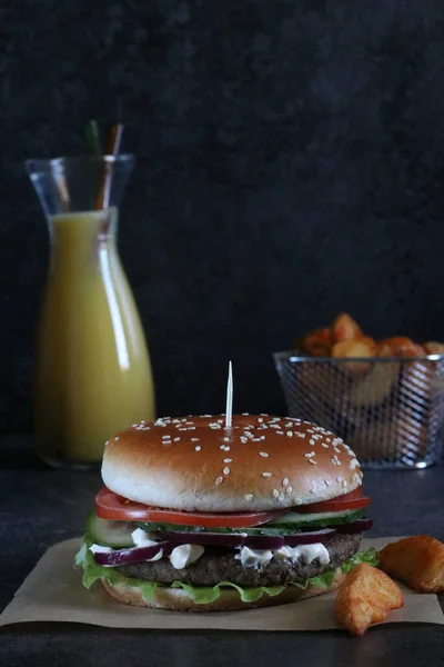 Yakın plan çekimde hamburger, kızarmış patates ve portakal suyu..