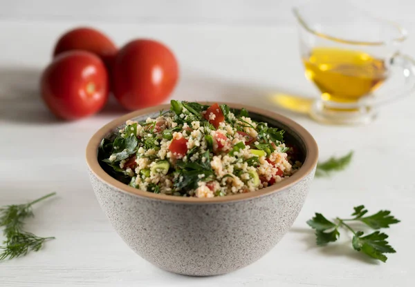 Gray ceramic bowl of Traditional Arabic salad Tabbouleh, side view