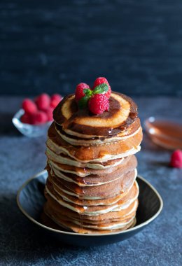 Koyu arkaplanda ahududu ve akçaağaç pekmezli krep yığını