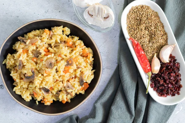 Vegetarian pilaf with mushrooms on a light background with gray textiles. — Stock Photo, Image