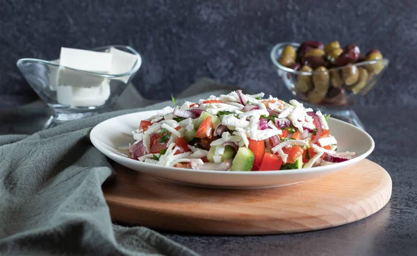 Shopska salade op houten plank, donkere achtergrond met grijs textiel — Stockfoto