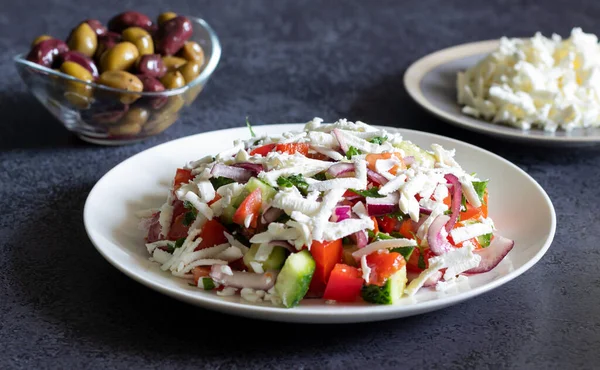 Bulgaarse shopska salade met groenten en brynza op donkere betonnen achtergrond — Stockfoto