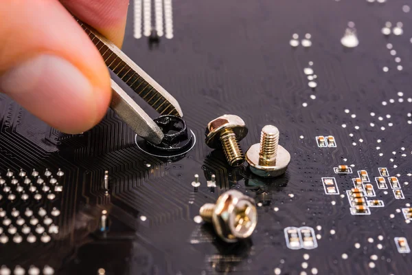 Computer repair, installation motherboard with screws — Stock Photo, Image