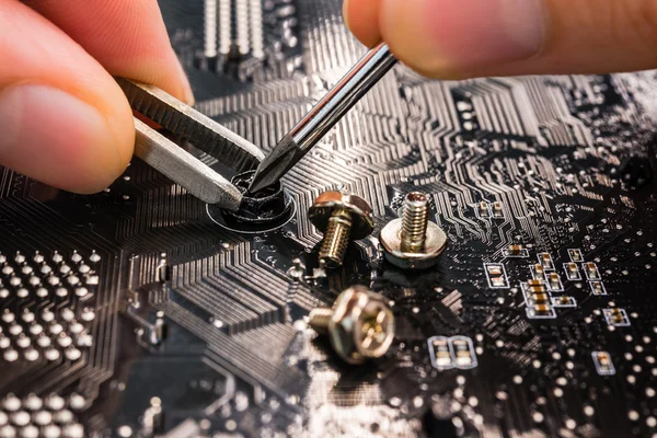 Computer repair, installation motherboard with screws — Stock Photo, Image