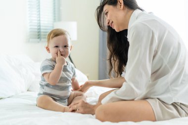 Beyaz bir anne yatak odasında tatlı bir çocukla oynaşıyor. Mutlu bir aile, çekici, şefkatli, genç bir anne sabahın erken saatlerinde yeni yürümeye başlayan oğluyla mutlulukla konuşuyor..