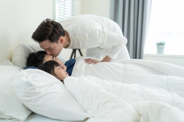 Asyalı eşcinsel ebeveynler evdeki yatak odasında uyuyan kızlarına bakarlar. Çekici genç LGBTQ adamı battaniyeyi rahat bir uykuya daldırıyor. Küçük bebek ve koca çifti sabahları yataklarında kestiriyor.