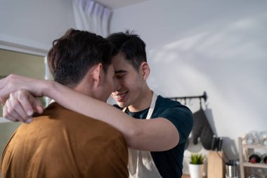 Asian attractive male LQBTQ hugging each other and starting foreplay. Handsome romantic man gay couple spending leisure time together making love in dark night room in house. Homosexual-LGBTQ concept.
