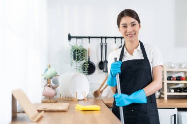Portrait of Asian young cleaning service woman worker working in house. Beautiful girl housewife housekeeper cleaner wear protective gloves and smile, looking at camera after doing housework or chores