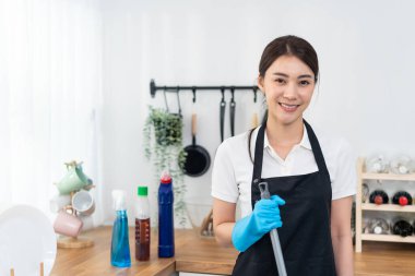 Portrait of Asian young cleaning service woman worker working in house. Beautiful girl housewife housekeeper cleaner wear protective gloves and smile, looking at camera after doing housework or chores
