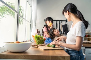 Asian happy family, mother spend time with young daughter in kitchen. Loving beautiful parent mom and little sibling cute girl child feel happy enjoy cook food for health at home. Healthy food concept