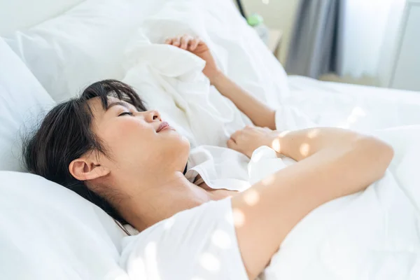 잠옷을 아시아의 아름다운 침실에서 잠에서 침대에 매력적 여자는 베개와 담요로 — 스톡 사진