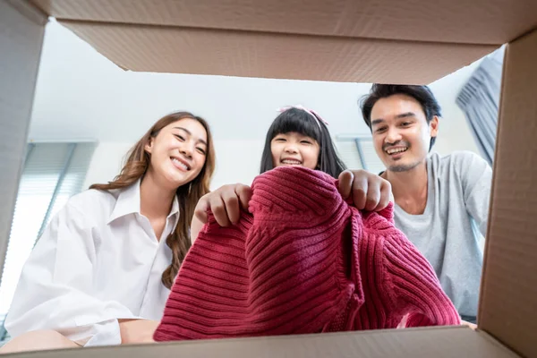 Asyalı sevimli küçük kız anne babadan hediye kutusunu aç. Mutlu aile, çocuk mutlu ve heyecanlı anne ve babadan gelen sürpriz için evde doğum günü partisini kutlamaya hazır..