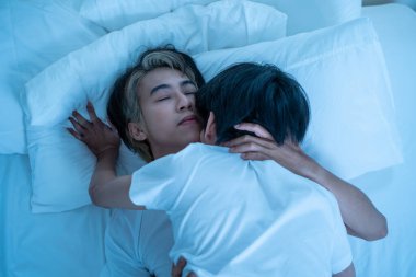 Asyalı çekici erkek LQBTQ ön sevişmeye ve evde sevişmeye başlıyor. Yakışıklı, romantik, eşcinsel çift birlikte vakit geçirip karanlık bir gece odasında sevişiyor. Homoseksüel-LGBTQ kavramı.