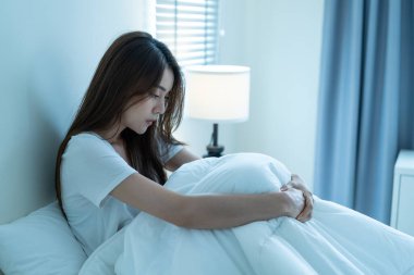 Asyalı güzel üzgün kız yatak odasında tek başına oturuyor. Çekici mutsuz genç kadın üzgün yalnız ve üzgün hissediyor. Hayat sorunu ve evdeki karanlık gece odasında kendine zarar vermeye çalışıyor..