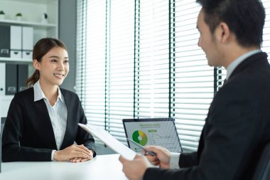 Kadın, ofisteki iş görüşmesi için İnsan Kaynakları müdürüne özgeçmişini ver. Kadın masada oturup, insan kaynakları müdürüyle iş yerindeki başvuru işi için görüşüyor. Sahte uygulama belgesi