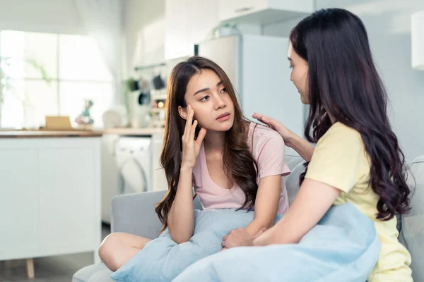 Asyalı güzel kadın, sorun için ağlayan kız arkadaşını rahatlatır. Çekici kadın desteği, teselli ve evde göz yaşları içinde stresli genç kız kardeşine empati kurmak. Aile ilişkisi.