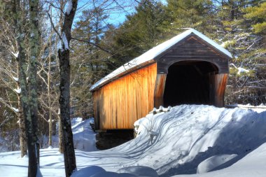Snow Covered Corbin Covered Bridge in new Hampshire. clipart