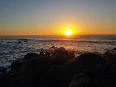 Denizin üzerinde gün batımı.