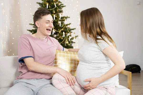 Felice coppia affascinante a casa per Natale. Buon marito e moglie incinta ridendo, concetto di vacanze — Foto Stock