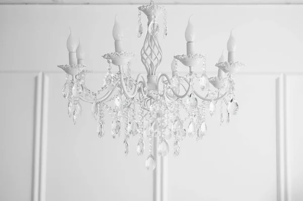 Vintage white chandelier decorated with beads or crystals over white wall — стоковое фото