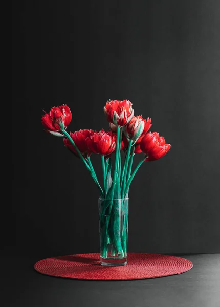 Siyah bir arka planda vazoda bir buket lale. Siyah arka planda vazoda bir buket lale. Çiçek kavramı ve geçmişi. Bu resim, bir blog yazısı, düğün kırtasiyesi için rüya gibi ve romantik bir görüntü getirmek için özellikle mükemmel.
