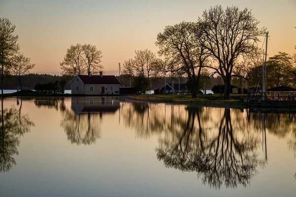 Gün batımından sonra Vnern Gölü 'nü Gta Kanalı' na bağlayan Sjtorp marina kilit sisteminin sakin sularındaki ağaçların yansıması..
