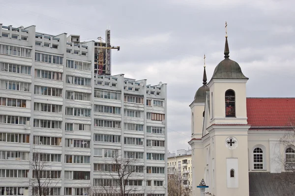 Edificio de apartamentos de varios pisos y la iglesia cristiana —  Fotos de Stock