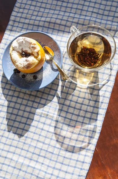 Апельсиновый десерт и чашка чая с золотой чайной ложкой — стоковое фото