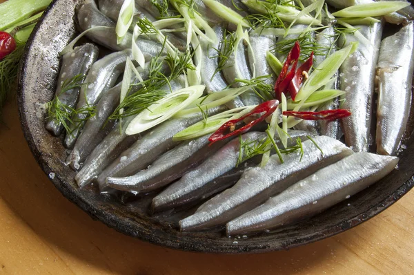 Pescado fresco cortando cebolla y pappers en una sartén vieja —  Fotos de Stock