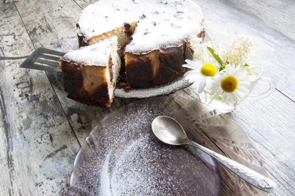 Tarta de queso en un plato de vidrio con ramo de manzanilla —  Fotos de Stock