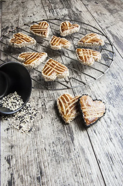 Kekse mit Sesam in Herzform auf dem Metallgitter — Stockfoto